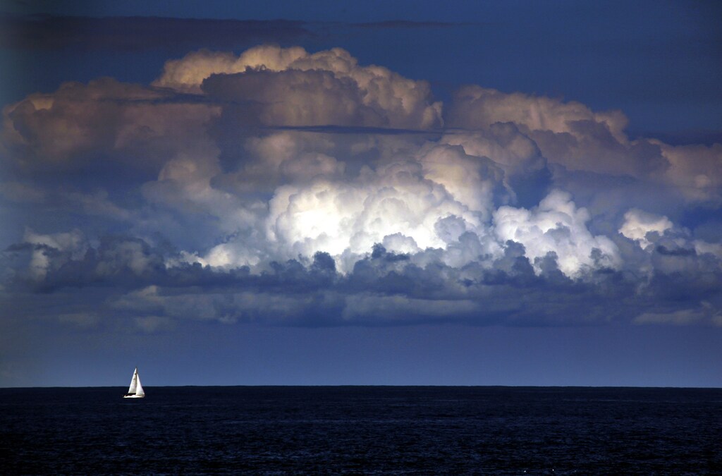 A storm cloud can be seen behind a yacht as it sails off the coast of Sydney March 31, 2014.