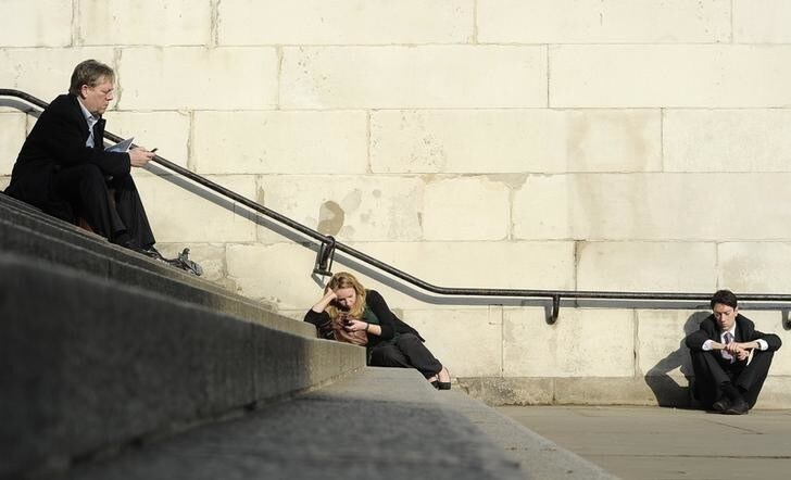 People sit in the sunshine in central London March 1, 2012. REUTERS/Paul Hackett (BRITAIN - Tags: CITYSPACE ENVIRONMENT)