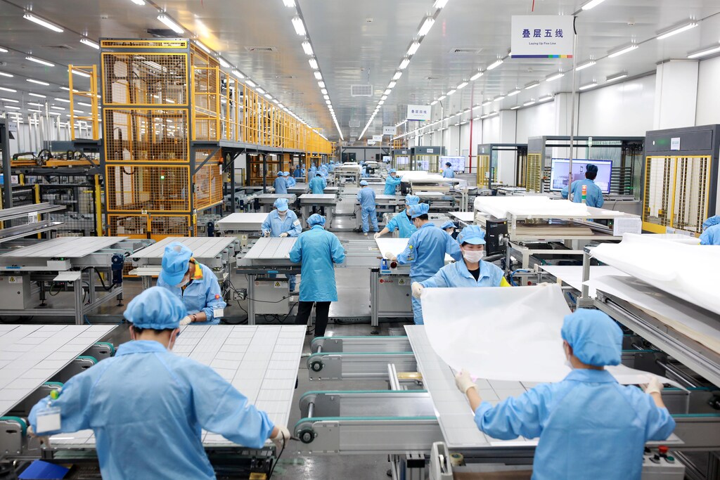Employees work on photovoltaic solar panels at a factory of Risen Energy in Ningbo, Zhejiang province, China February 21, 2019. Picture taken February 21, 2019. Zhejiang Daily via REUTERS ATTENTION EDITORS - THIS IMAGE WAS PROVIDED BY A THIRD PARTY. CHINA OUT.
