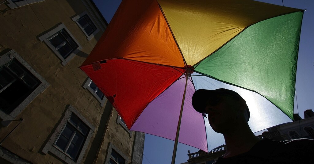 A man holds a umbrella with the colours of rainbow during the Gay Pride Parade in Lisbon June 28, 2008.