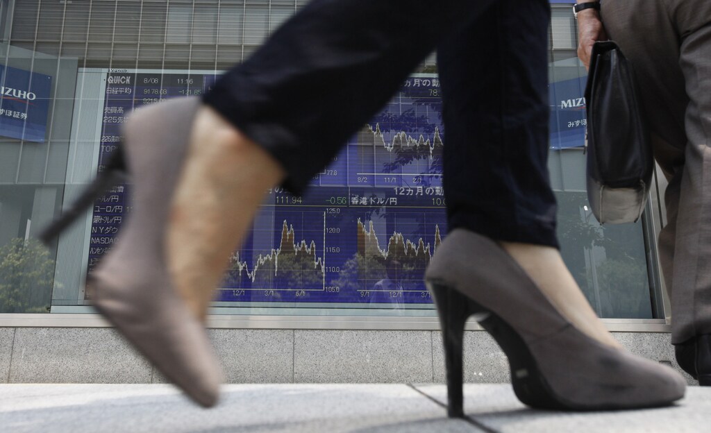 A woman walks past a board showing Japanese Yen's exchange rate against other countries' currency outside a brokerage in Tokyo August 8, 2011. Japanese Finance Minister Yoshihiko Noda said on Monday that market trust in the dollar and U.S. Treasuries has not wavered, signalling Tokyo's readiness to maintain its massive holdings of U.S. government bonds. REUTERS/Kim Kyung-Hoon (JAPAN - Tags: BUSINESS POLITICS) - GM1E7880VW701