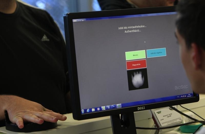 A Ferencvaros soccer fan has his palm registered in the biometric identification system used for entry into the team's home stadium, in Budapest, September 28, 2014. A Hungarian invention, the scanner identifies a fan based on five million palm vein data points. The developers say this is the fastest existing system for the safe identification of big crowds at sports and other events. Still, the scanner was the last straw for the hard core of Fradi fans who had been upset anyway by the introduction of club cards, a rise in ticket prices and ever stricter regulations of the behaviour of soccer fans in and around the stadium. Picture taken September 28, 2014.