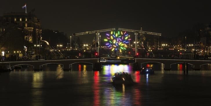 "Big Tree", made of many colored LED branches by the French artist Jacques Rival, is seen through the Magere brug (Skinny Bridge) as part of the Amsterdam Light Festival in Amsterdam December 7, 2013. The fifth Amsterdam Light Festival, a winter light festival showcasing some 30 light sculptures and projections by international artists, runs till January 19, 2014. REUTERS/Michael Kooren (NETHERLANDS -