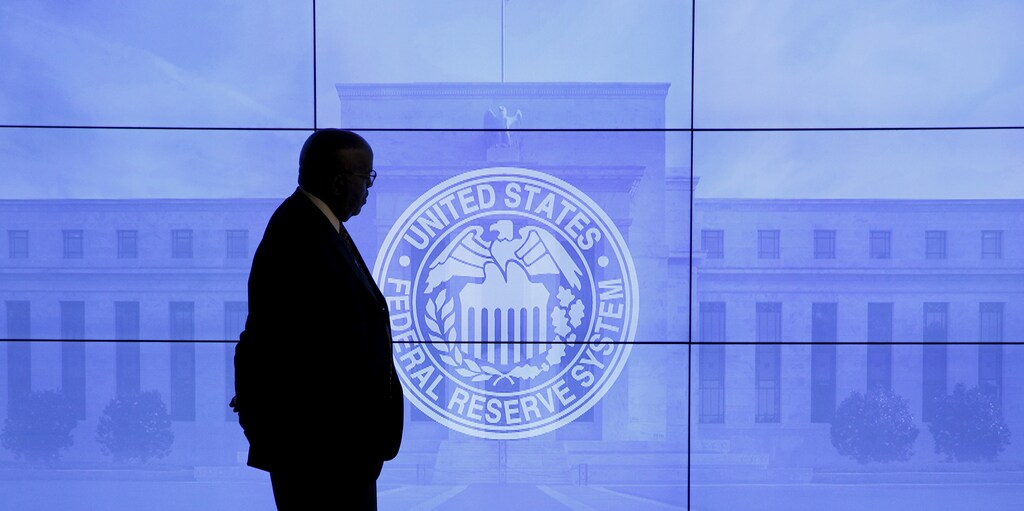 A security guard walks in front of an image of the Federal Reserve before the arrival of U.S. Federal Reserve Chair Janet Yellen to give a news conference following the two-day Federal Open Market Committee (FOMC) policy meeting in Washington, March 16, 2016.