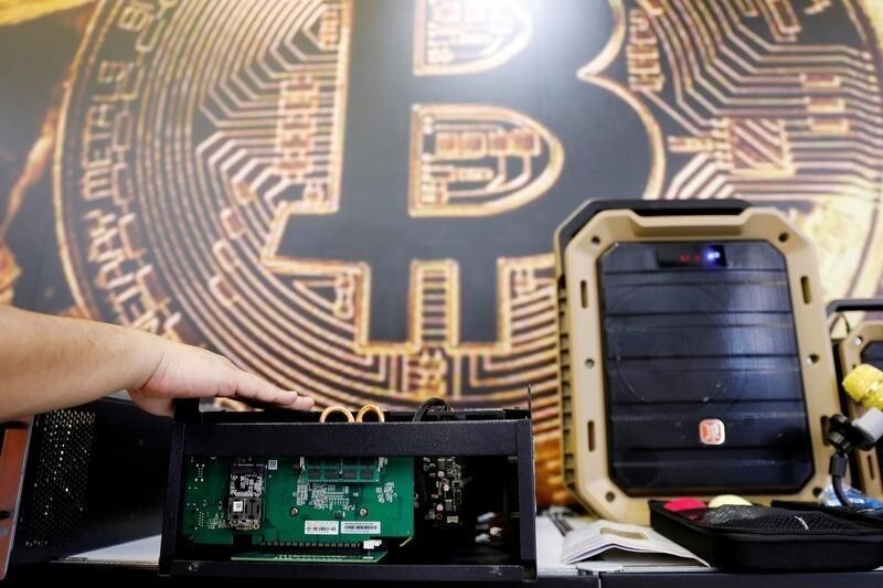A cryptocurrency mining computer is seen in front of bitcoin logo during the annual Computex computer exhibition in Taipei, Taiwan June 5, 2018. REUTERS/Tyrone Siu - RC115698ECF0