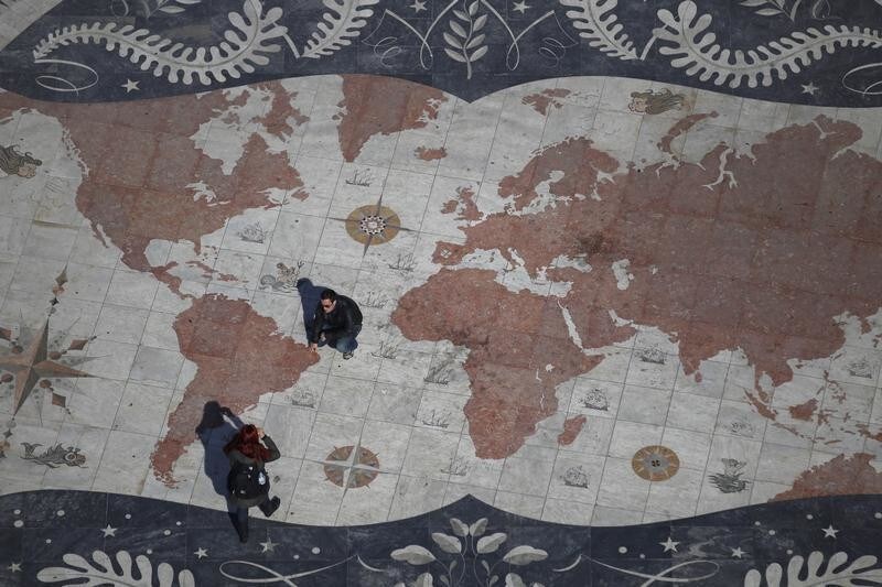 A man is photographed on a square decorated with a giant world map, with marks showing former Portuguese colonies, in Lisbon March 6, 2012. Portugal flourished as a global power with explorers like Vasco da Gama and Pedro Alvares Cabral building an empire which lasted for 600 years. Now a new wave of adventurers is once again seeking work, and hopefully fortune, elsewhere. Emigrating is fast becoming a preferred option for many seeking a decent living as their bailed-out economy suffers under debt, low growth and poor competitiveness. Portugal's booming ex-colonies in Africa and Brazil are a natural choice. Picture taken March 6, 2012. To match Feature PORTUGAL/EMIGRATION REUTERS/Rafael Marchante (PORTUGAL - Tags: BUSINESS SOCIETY IMMIGRATION) - RTR2ZBVZ