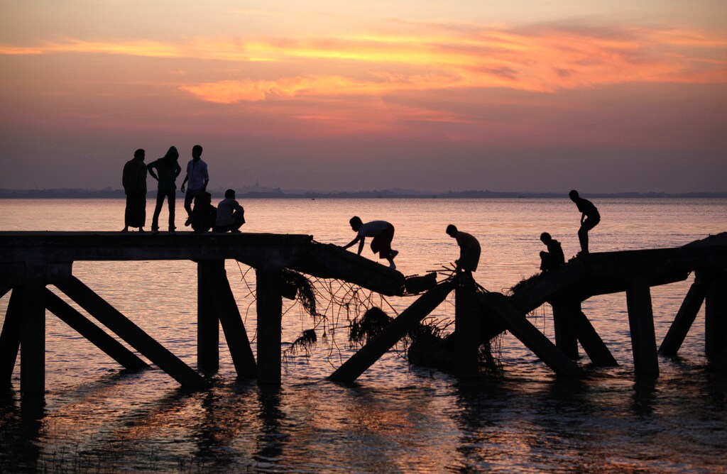 Boys cross a broken bridge across the Yangon river December 27, 2010.