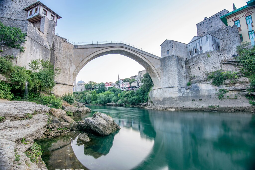 A body of water and old bridge in Mostar, Bosnia and Herzegovina: The Balkans strategic importance stretches beyond more than being a geopolitical trouble spot