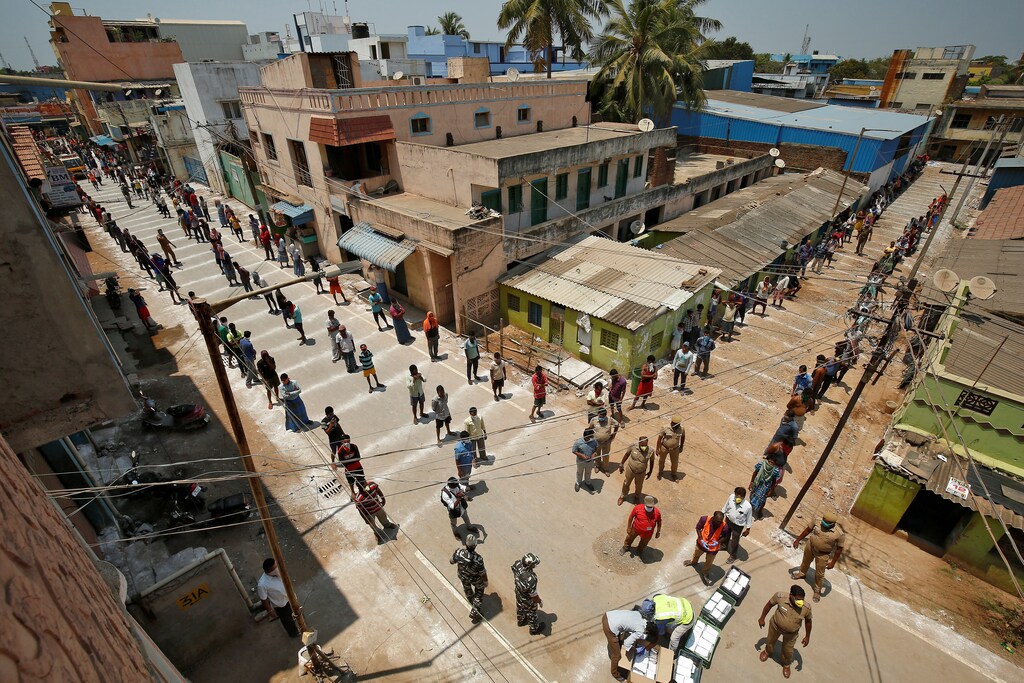 People stand on the lines drawn to maintain safe distance as they wait to receive free food being distributed by Central Reserve Police Force (CRPF) during a 21-day nationwide lockdown to slow the spreading of coronavirus disease (COVID-19) in Chennai, India, April 1, 2020. REUTERS/P. Ravikumar TPX IMAGES OF THE DAY - RC2MVF9VNQNR