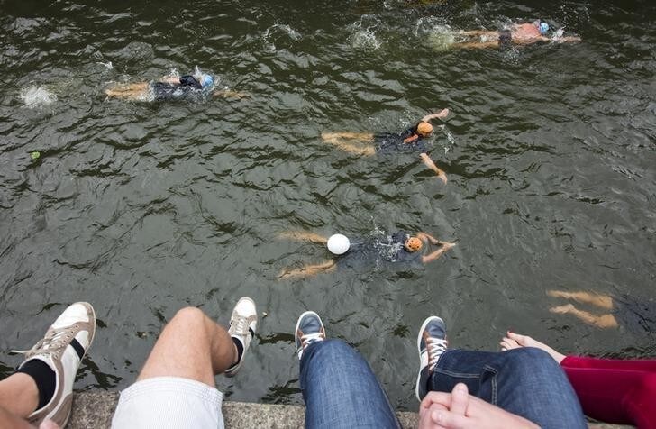 Spectators look at some two thousand swimmers as they take off from the Maritime museum for the second Amsterdam City Swim in Amsterdam September 8, 2013. The Amsterdam City Swim is held to raise money for research into Amyotrophic lateral sclerosis (ALS). The participants swam a total of 2013 meters in the canals of Amsterdam. REUTERS/Cris Toala Olivares (NETHERLANDS - Tags: SPORT SWIMMING SOCIETY)