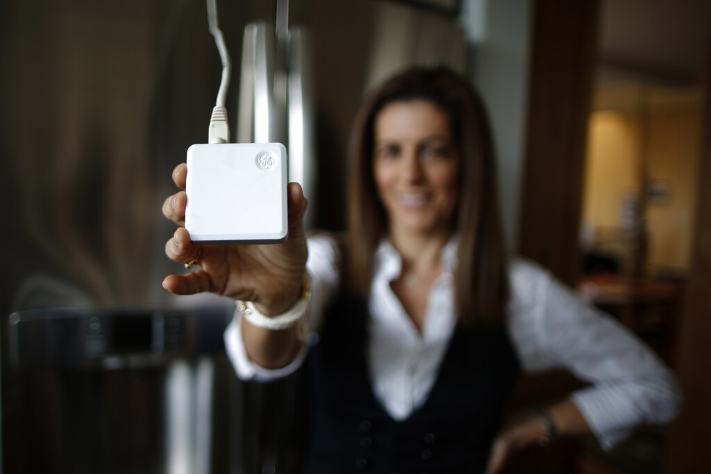 Computer science professor Christa Lopes holds an appliance communication module attached to the refrigerator in her home in Irvine, California January 26, 2015. Lopes said the Irvine Smart Grid Demonstration, a $79 million project funded half by federal stimulus money and half by Edison and partners like UC Irvine, cut her electric bill to zero in the summer. The $12 billion utility's research team Southern California Edison is testing everything from charging electronic vehicles via cell phone to devices that smooth out the power created by rooftop solar panels. Those are some of the roughly 60 projects in the works at Edison's Advanced Technology division. It has a small $19 million annual budget, but its influence far exceeds that. Picture taken January 26, 2015.
