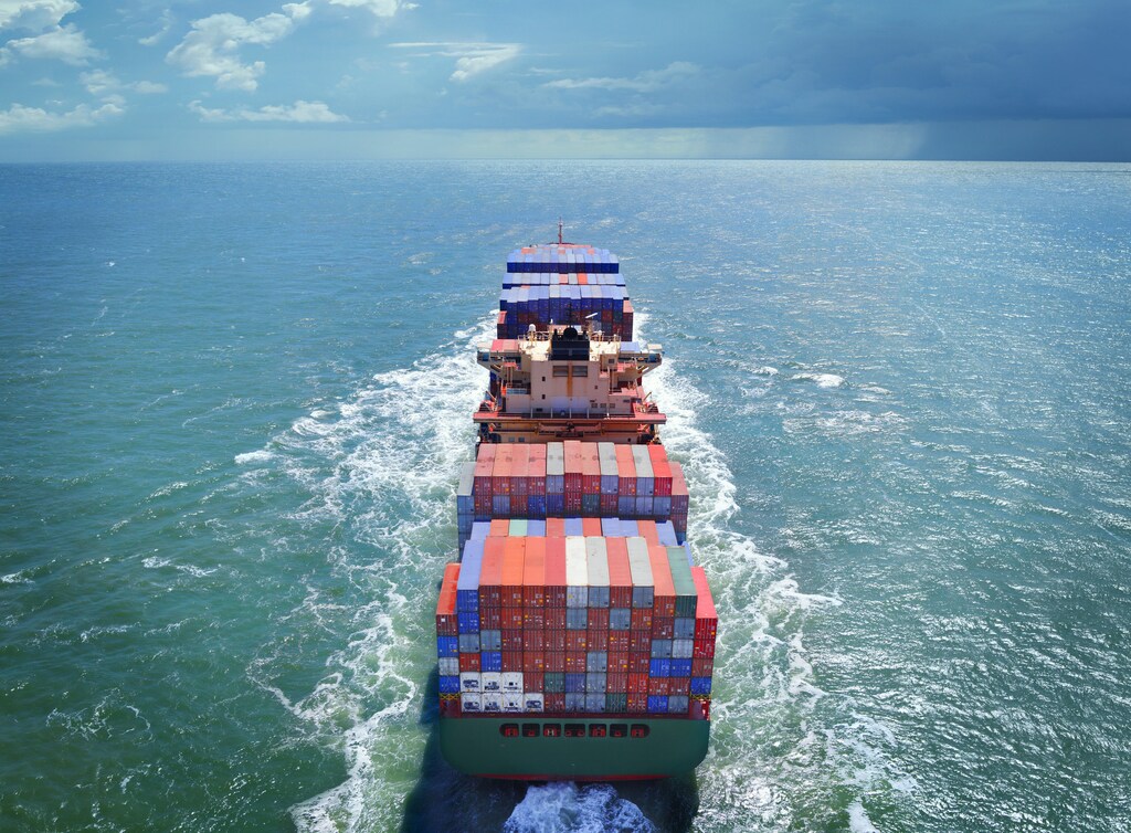 Aerial view of freight ship with cargo containers on the sea