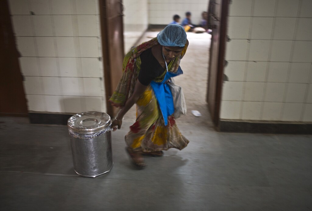 A worker pulls a container carrying a free mid-day meal, distributed by a government-run primary school, for school children in New Delhi July 19, 2013. Health officials in the eastern Indian state of Bihar were due on Friday to release autopsy results for many of the 23 school children who died on Tuesday after vomiting and convulsing with agonizing stomach cramps. The children fell ill within minutes after eating a lunch provided by their school in the village of Gandaman. The free meals are part of a national scheme aimed at tackling malnutrition and encouraging children to attend school. REUTERS/Ahmad Masood (INDIA - Tags: DISASTER HEALTH FOOD EDUCATION) - GM1E97J1OVL01