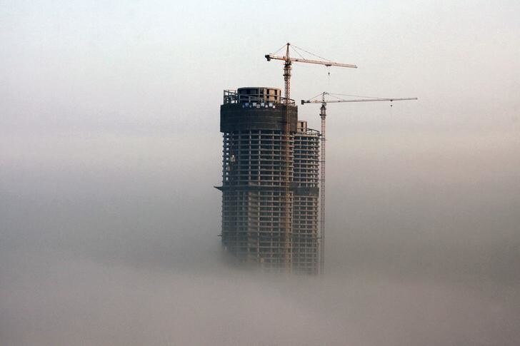 A building under construction is seen in fog in Rizhao, Shandong province, February 26, 2014. China's property market is likely to see at most a moderate correction in prices in some small cities this year, according to a Reuters straw poll of 13 industry watchers this week, with the chance of a sharp fall in prices nationwide very slim. Picture taken February 26, 2014. REUTERS/Stringer (CHINA - Tags: BUSINESS CONSTRUCTION REAL ESTATE ENVIRONMENT) CHINA OUT. NO COMMERCIAL OR EDITORIAL SALES IN CHINA