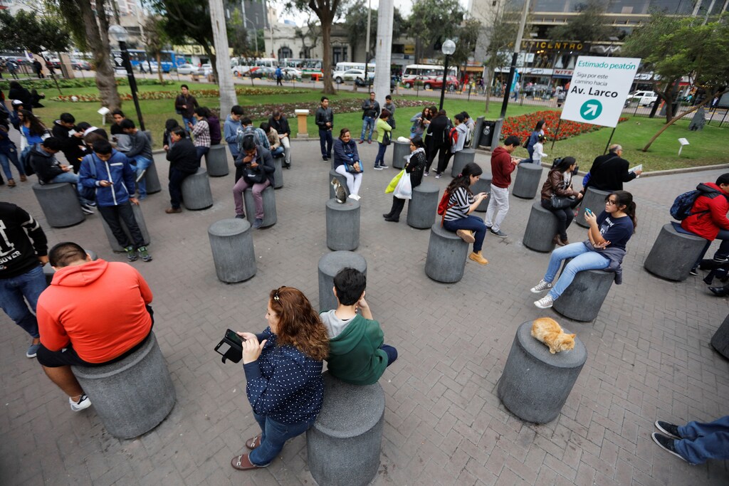 People play the augmented reality mobile game "Pokemon Go" at Kennedy park in Lima, Peru, August 6, 2016.