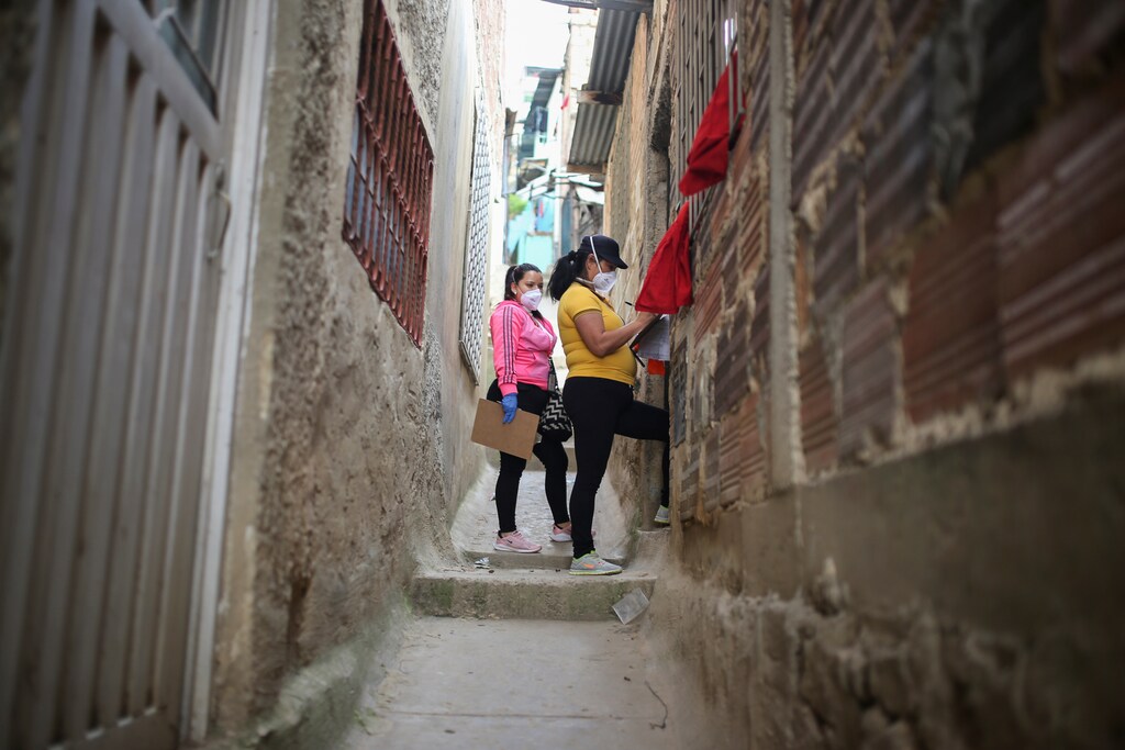 Mayoral employees walk through a poor neighborhood during a day of food aid delivery, amid the outbreak of the coronavirus disease (COVID-19) in Bogota, Colombia April 21, 2020.