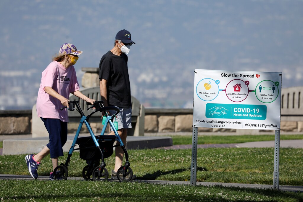 An elderly couple wear masks as they get some exercise in a park during the outbreak of the coronavirus disease (COVID-19) in Signal Hill, California, U.S., April 23, 2020. REUTERS/Mike Blake - RC2IAG9D9T0C