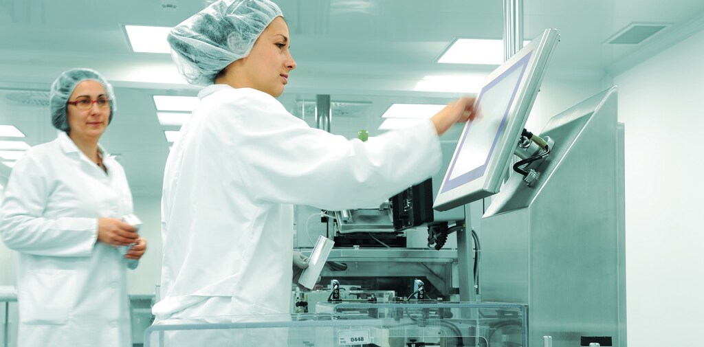 Two female healthcare professionals work in a hospital laboratory using virtual health care technologies.