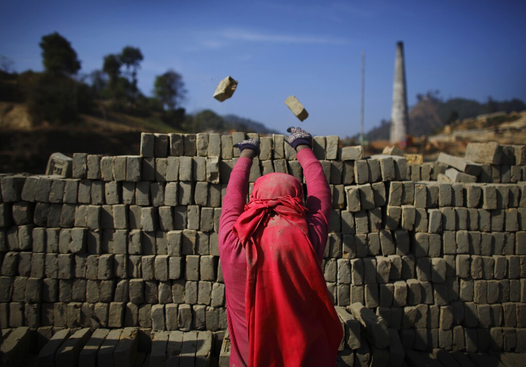A girl throws away broken bricks while unloading bricks at a brick factory in Lalitpur December 19, 2012. REUTERS/Navesh Chitrakar (NEPAL - Tags: BUSINESS CONSTRUCTION SOCIETY TPX IMAGES OF THE DAY) - GM1E8CJ1HTR01