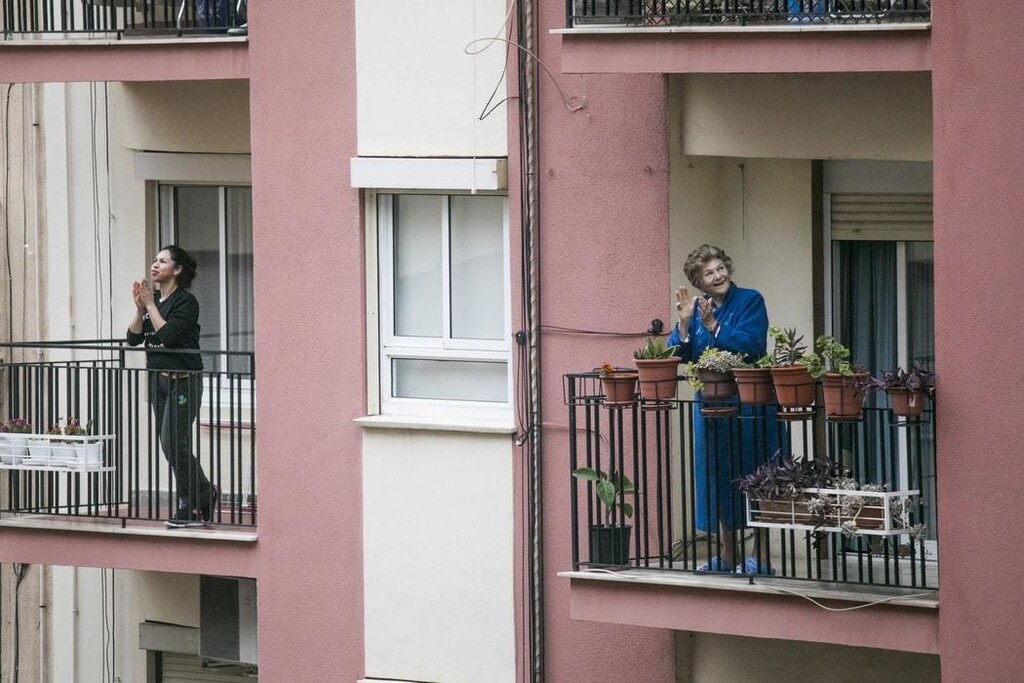 People stand on their balconies as Latin America introduces lockdown measures.
