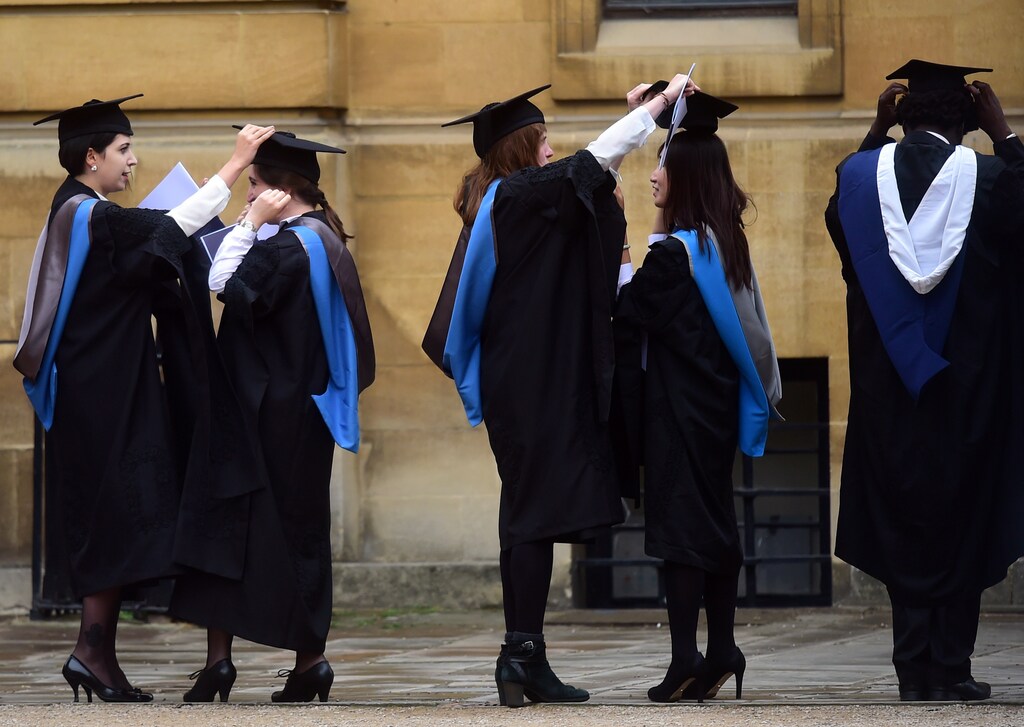 Graduates gather outside the Sheldonian Theatre after a graduation ceremony at Oxford University, in Oxford, Britain July 15, 2017. REUTERS/Hannah McKay - RTX3BKLR