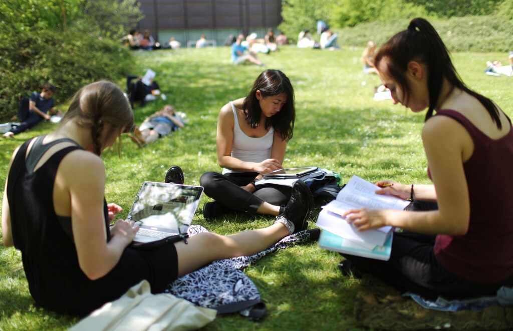 Students sit on grass at the campus of the Free University of Berlin "Freie Universitaet Berlin" in Berlin, Germany, May 11, 2016. REUTERS/Hannibal Hanschke/File Photo - RTX2G5LR