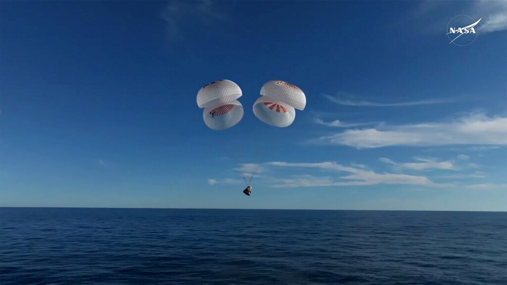 The Crew Dragon capsule carrying NASA astronauts Butch Wilmore, Suni Williams, and two others parachutes down before splashing off Florida’s coast on March 18, 2025, after returning from the ISS.