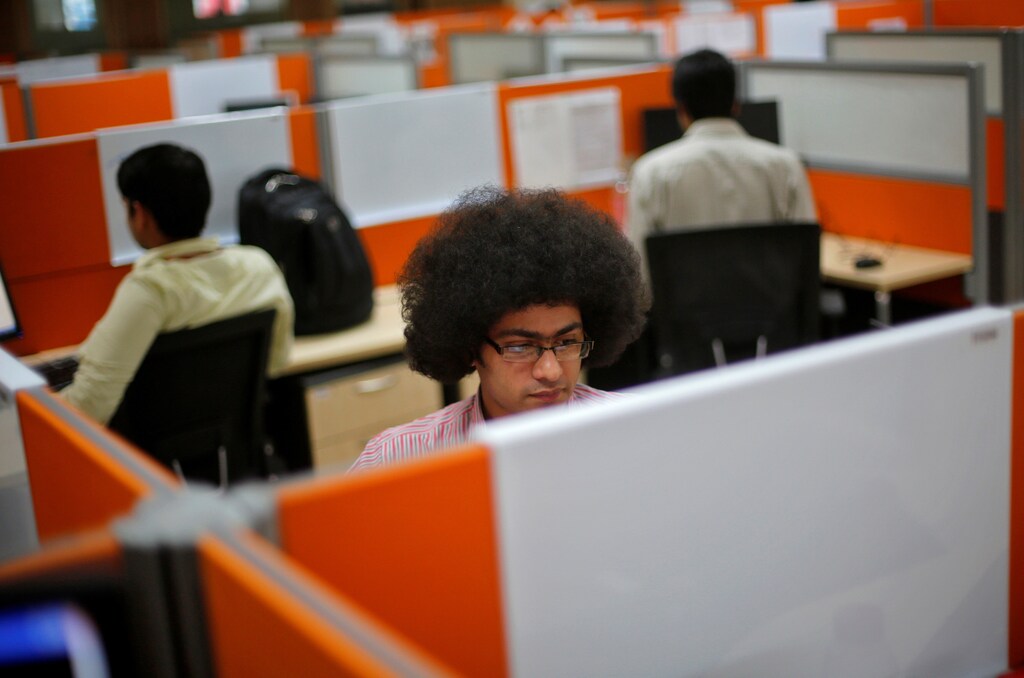 Employees work at their desks inside Tech Mahindra office building in Noida on the outskirts of New Delhi March 18, 2013. India's IT outsourcers are promoting "mini CEOs" capable of running businesses on their own, while trimming down on the hordes of entry-level computer coders they normally hire as they try to squeeze more profits out of their staff. To match Analysis INDIA-TECH/STAFFING Picture taken March 18, 2013. REUTERS/Adnan Abidi THIS PICTURE IS ONLY TO BE PUBLISHED WITH THE STORY SLUGGED INDIA-TECH/STAFFING, WITH THE HEADLINE "The End of Indian IT Staffing As We Know It". - GM1E93P0C9X01