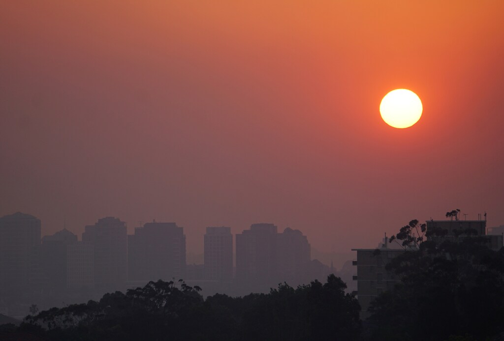 High-rise buildings are seen through smoke from bushfires during sunset in Sydney, Australia, November 11, 2019