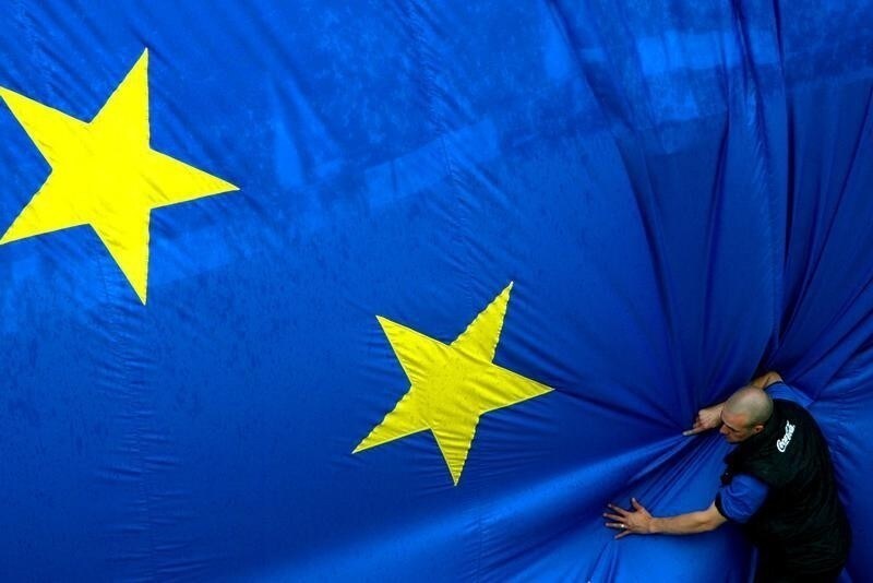 A worker adjusts a 150 metre-square European flag during a celebration in Brussels' Jubilee Park to mark the expansion of the European Union to 25 from 15 states on April 30, 2004. Cyprus, the Czech Republic, Estonia, Hungary, Latvia, Lithuania, Malta, Poland, Slovakia and Slovenia will join the European Union on May 1. REUTERS/Francois Lenoir - RTR1E8JX