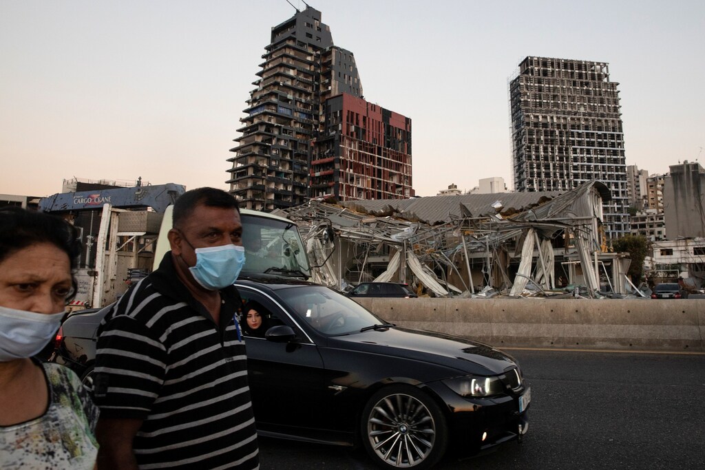 People pass by damaged buildings next to the port area, in the aftermath of a massive explosion, in Beirut, Lebanon, August 16, 2020. REUTERS/Alkis Konstantinidis - RC26FI9BKACH