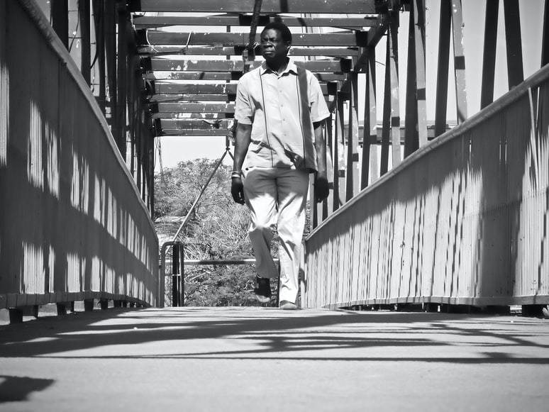 a man walking across Manda Hill Bridge in Lusaka, Zambia