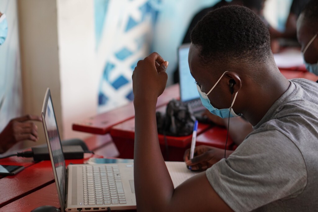 this student in Ghana is wearing a mask while working