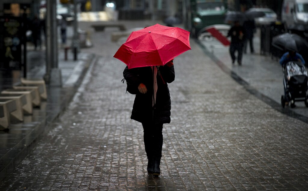 A woman walks on Broad St. past the New York Stock Exchange during the morning commute April 30, 2014. REUTERS/Brendan McDermid (UNITED STATES - Tags: BUSINESS TPX IMAGES OF THE DAY) - GM1EA5100RA02