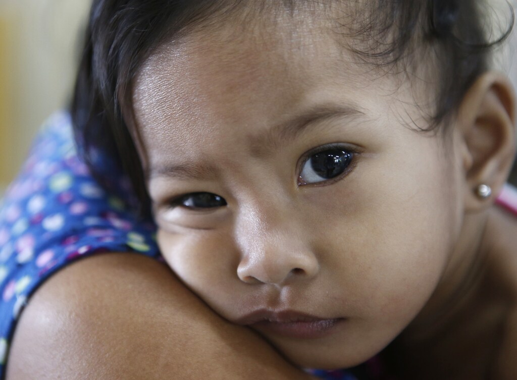 A girl who survived Typhoon Haiyan and receiving treatment in the severe malnutrition program by humanitarian agency ACF (Action Against Hunger) International leans on the shoulder of her mother at Eastern Visayas Regional Medical Center in Tacloban city in central Philippines November 6, 2014. The Philippines are preparing to commemorate victims of Typhoon Haiyan, ahead of the one-year anniversary of the disaster on November 8, according to a government official. REUTERS/Erik De Castro (PHILIPPINES - Tags: ENVIRONMENT DISASTER SOCIETY ANNIVERSARY HEALTH) - RTR4D2C0