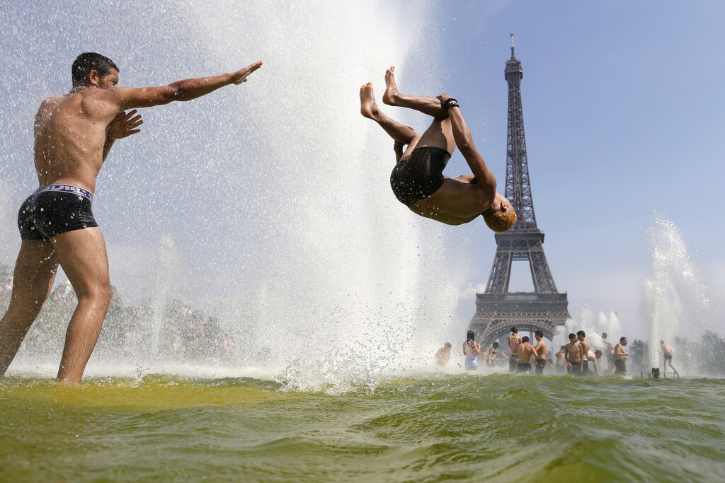 A man jumps in a fountain of the Trocadero Square in front of the Eiffel Tower as hot summer temperatures continue in Paris July 22, 2013. REUTERS/Benoit Tessier (FRANCE - Tags: TRAVEL ENVIRONMENT SOCIETY) - PM1E97M1AI601