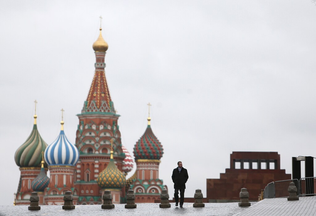 A man walks along Red Square, with the mausoleum of Soviet state founder Vladimir Lenin (R) and St. Basil's cathedral seen in the background, in central Moscow, Russia December 21, 2015. REUTERS/Maxim Shemetov - RTX1ZKOF
