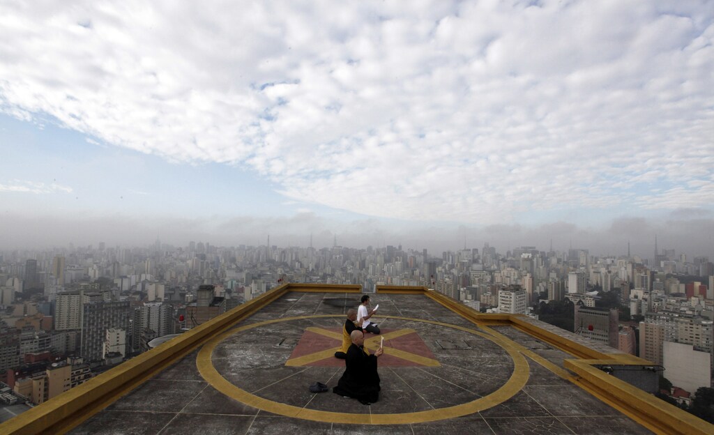 Buddhist monks Seigen (bottom), Jisho Handa and Fabricio Costa (top) from the Busshinji temple, meditate on the helipad of Copan building in downtown Sao Paulo .