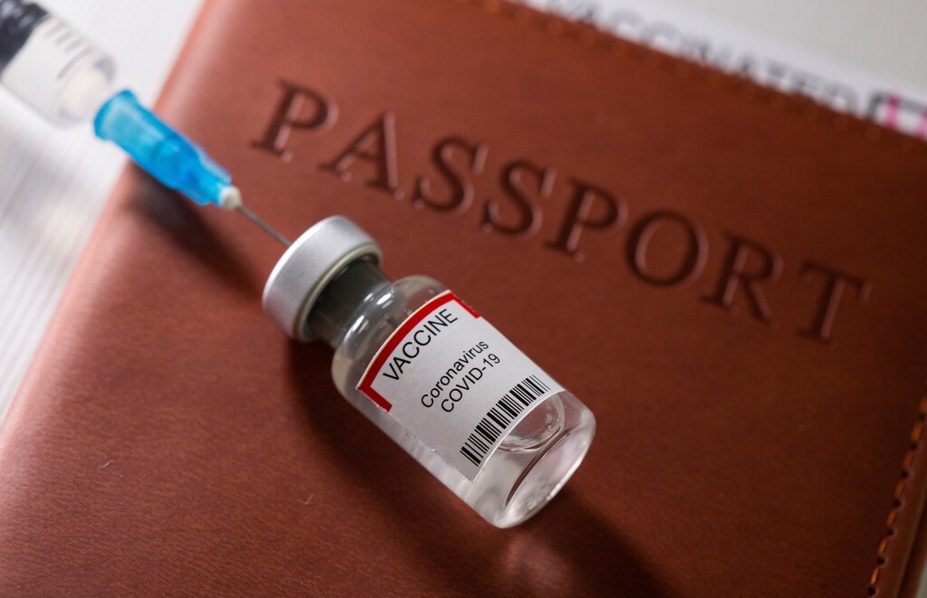A syringe and a vial labelled "coronavirus disease (COVID-19) vaccine" are placed on a passport in this illustration taken April 27, 2021. REUTERS/Dado Ruvic/Illustration - RC2D4N9XPL5S