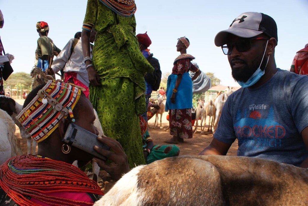 image of a health worker in Laisamis showing a woman how to receive weather alerts through the myAnga app