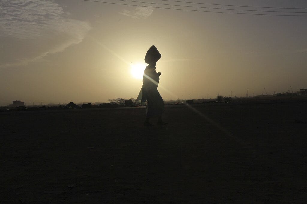 A Sudanese woman walks during sunrise on the first day of elections in Khartoum April 11, 2010. Sudan holds historic multi-party elections on Sunday that have been marred already by fraud allegations and will test the fragile unity of a nation divided by decades of civil conflict. REUTERS/Mohamed Nureldin (SUDAN - Tags: POLITICS ELECTIONS SOCIETY) - GM1E64B12HD01