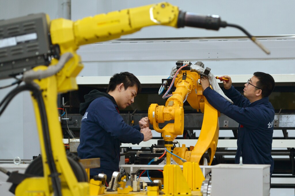 Men work on a production line manufacturing robotic arms at a factory in Huzhou, Zhejiang province, China January 8, 2019
