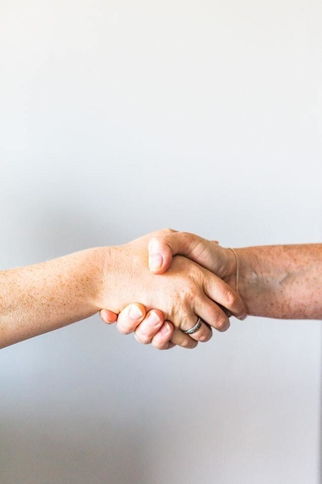 A close up photo of two hands shaking