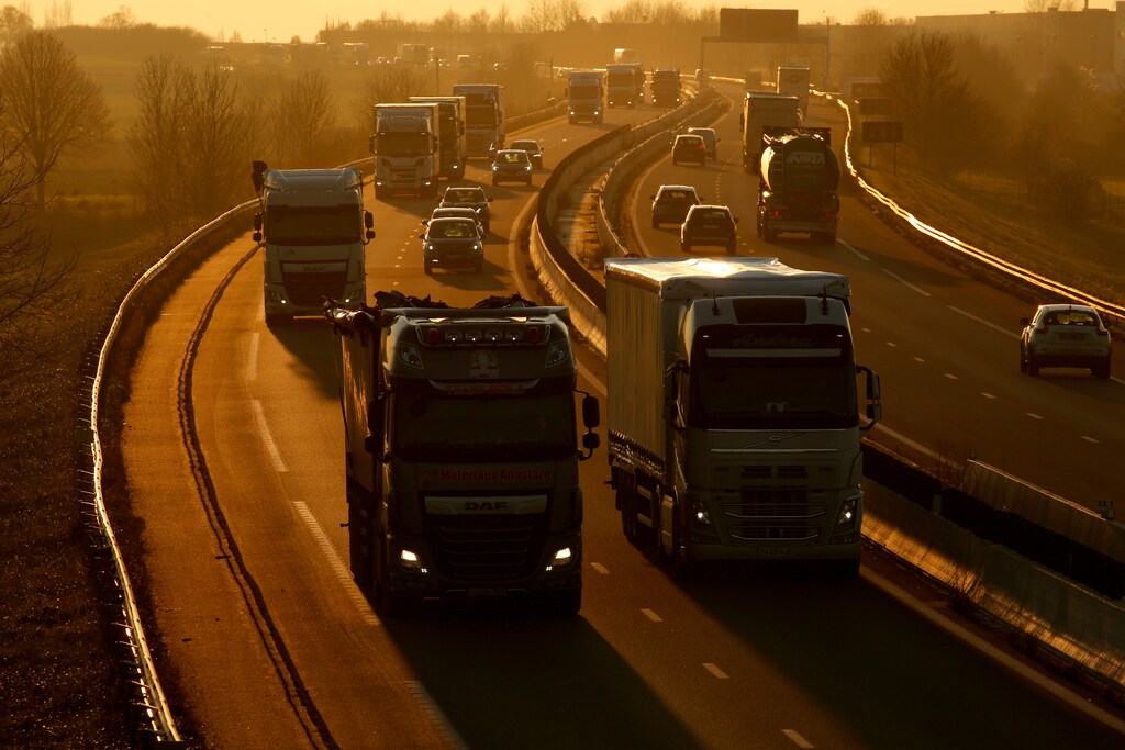 Trucks and cars drive on the Paris-Bruxelles highway during sunset in Tilloy-lez-Cambrai, France, December 4, 2019