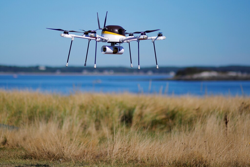 A drone, made by CyPhy Works, carries a UPS package on Children's Island off the coast of Beverly, Massachusetts, U.S. September 22, 2016, during UPS's demonstration of a drone making a commercial delivery of a package to a remote or difficult-to-access location. Picture taken September 22, 2016. REUTERS/Brian Snyder - S1BEUCYKOVAA