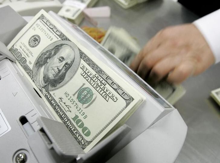 An employee of the Korea Exchange Bank counts one hundred dollar notes at the bank's headquarters in Seoul February 24, 2009. Asian shares fell on Tuesday, with Japan's Nikkei flirting with a 26-year low, as concerns grew about the global financial system, while emerging currencies such as the South Korean won extended their recent sell-off. REUTERS/Jo Yong-Hak (SOUTH KOREA)