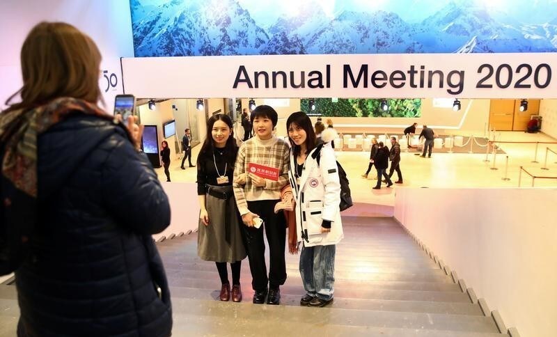 People pose for a picture at the venue of the World Economic Forum (WEF) during preparations for the annual meeting in the Swiss Alps resort of Davos, Switzerland January 19, 2020. REUTERS/Denis Balibouse - RC22JE9D05TL