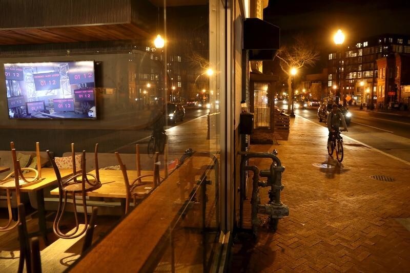 A man rides his bike along a commercial area of downtown Washington as restaurants, bar and museums are closed to the public as a precaution to avoid the spread of the coronavirus (COVID-19), in Washington, U.S., March 17, 2020. REUTERS/Carlos Barria - RC22MF9W9NYR