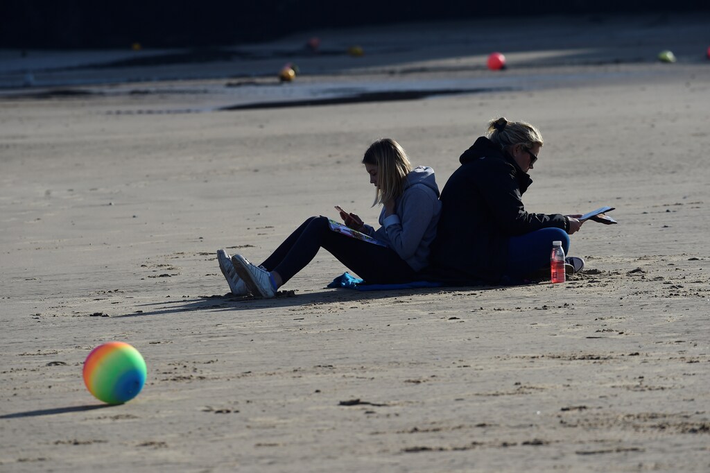 People relax on the beach at Tenby Harbour, Tenby, Pembrokeshire, Wales, Britain February 25, 2019. REUTERS/Rebecca Naden - RC1BEB2A90D0