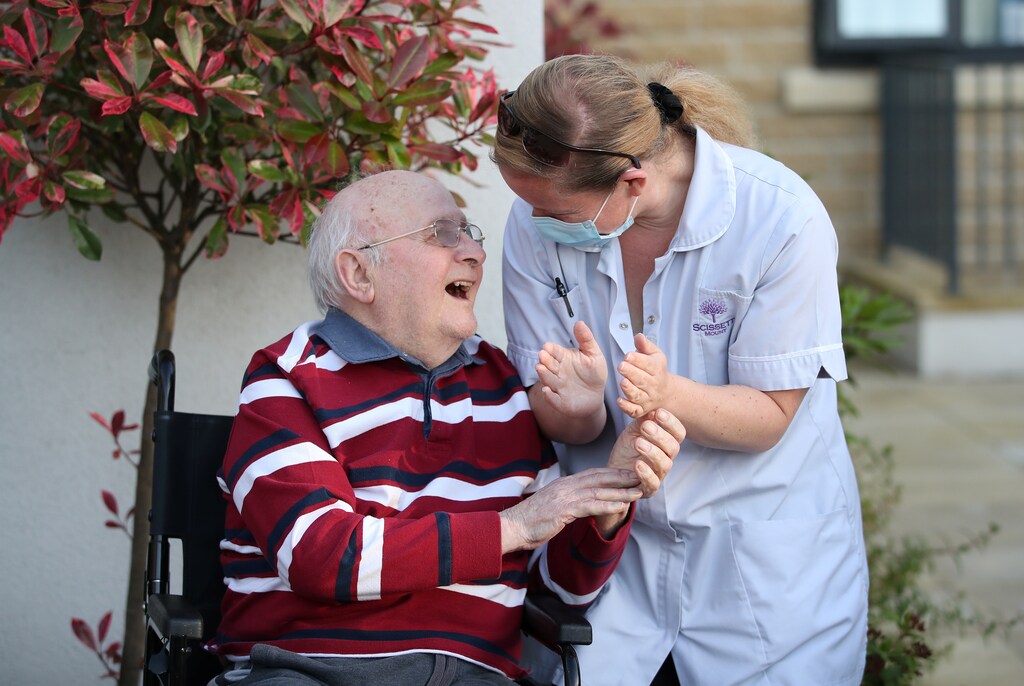 A Care worker and resident of the Scisset Mount Care Home react during the last day of the Clap for our Carers campaign in support of the NHS, following the outbreak of the coronavirus disease (COVID-19), Huddersfield, Britain, May 28, 2020.